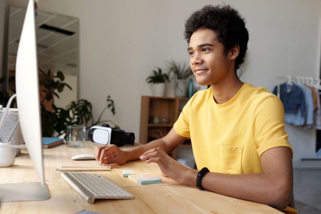 Young man wearing yellow shirt using computer