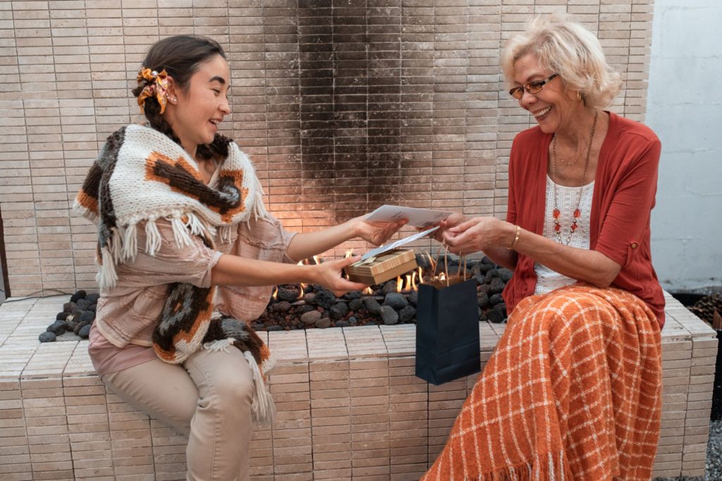 Younger woman happily exchanging gift with older woman