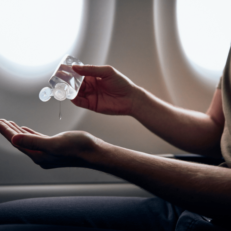 Man sanitizing hands on plane