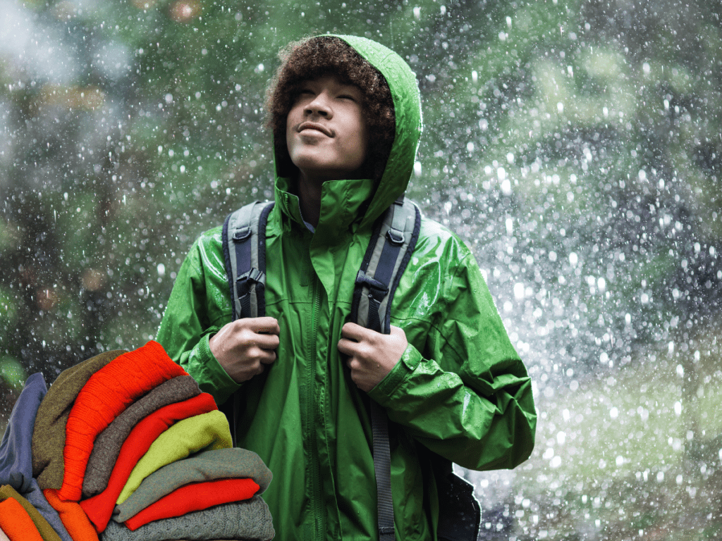 Man wearing green waterproof coat with layers in rain