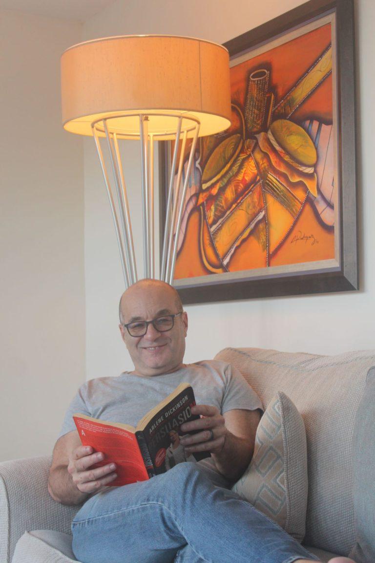 Nick Abbott reading under lamp in living room