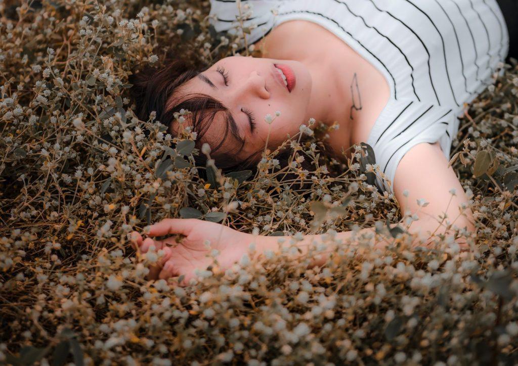 Young lady relaxing among plants and flowers