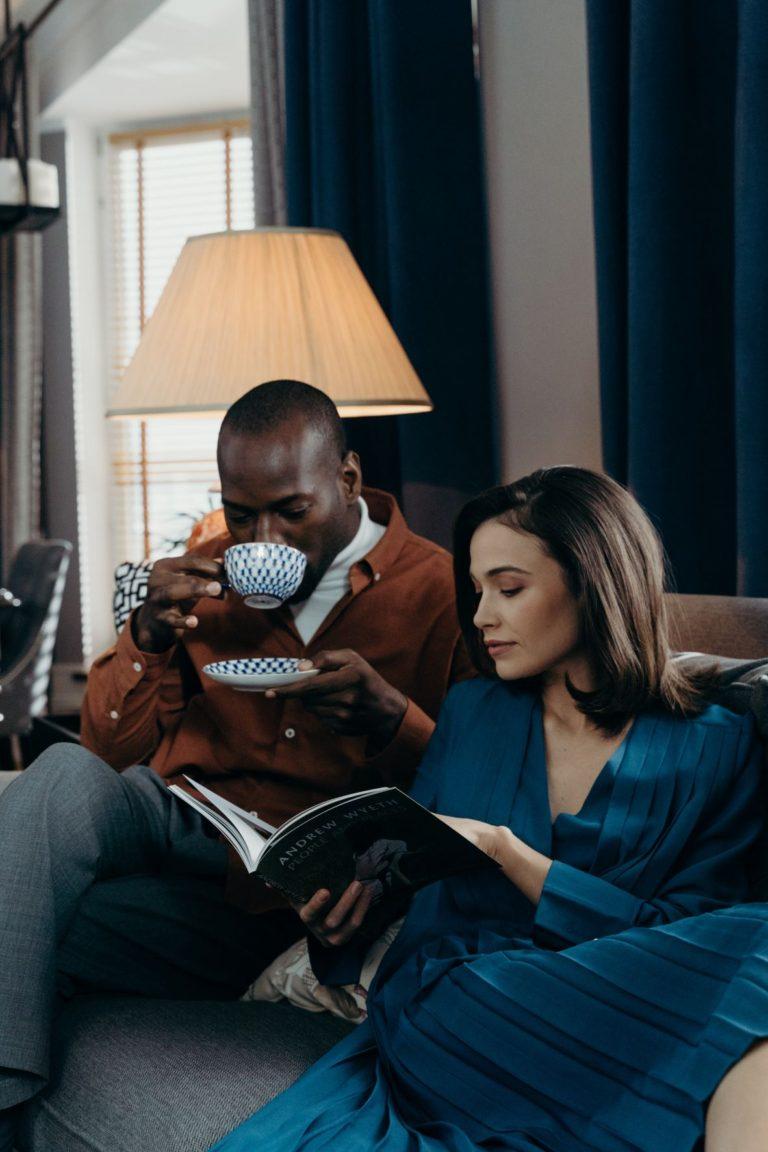 Couple having tea & reading next to lamp