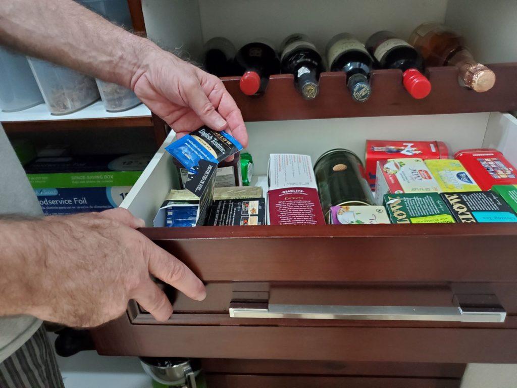 Nick Abbott selecting tea from pantry drawer