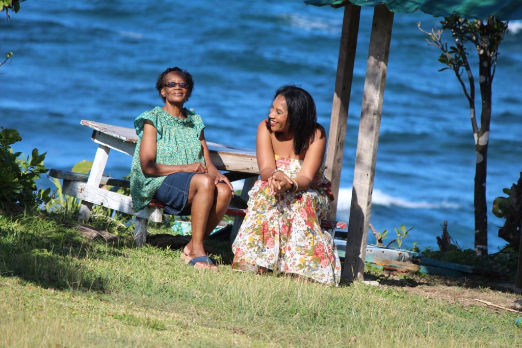 Monique Abbott sitting on bench with her mother at Robin's Bay, St. Mary, Jamaica