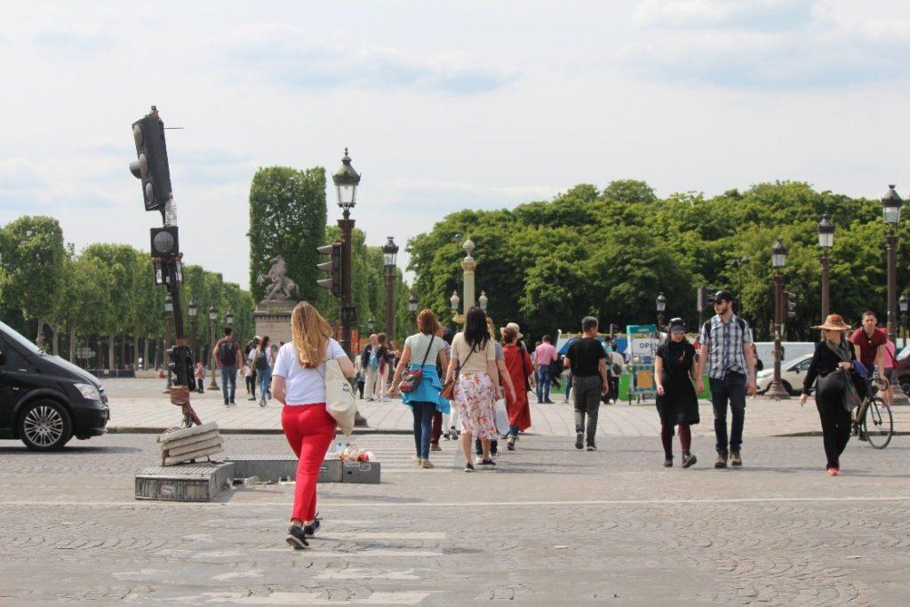 Lady wearing red pants walking across street on pedestrian crossing