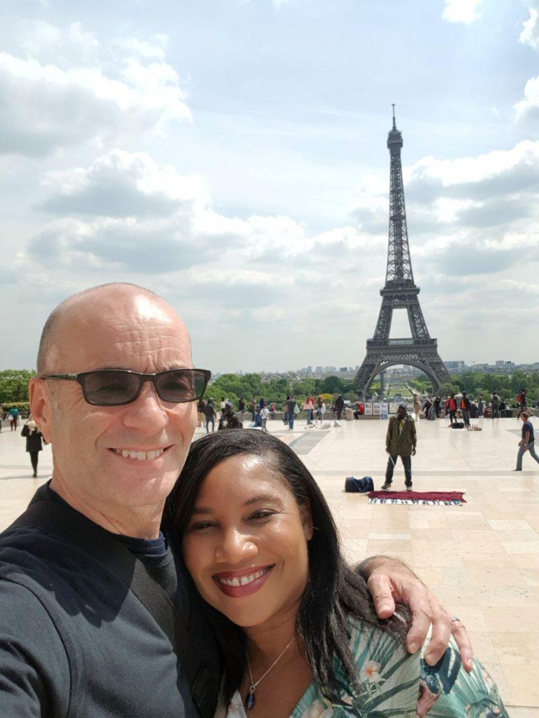 Monique & Nick Abbott standing in front of Eiffel Tower in Paris