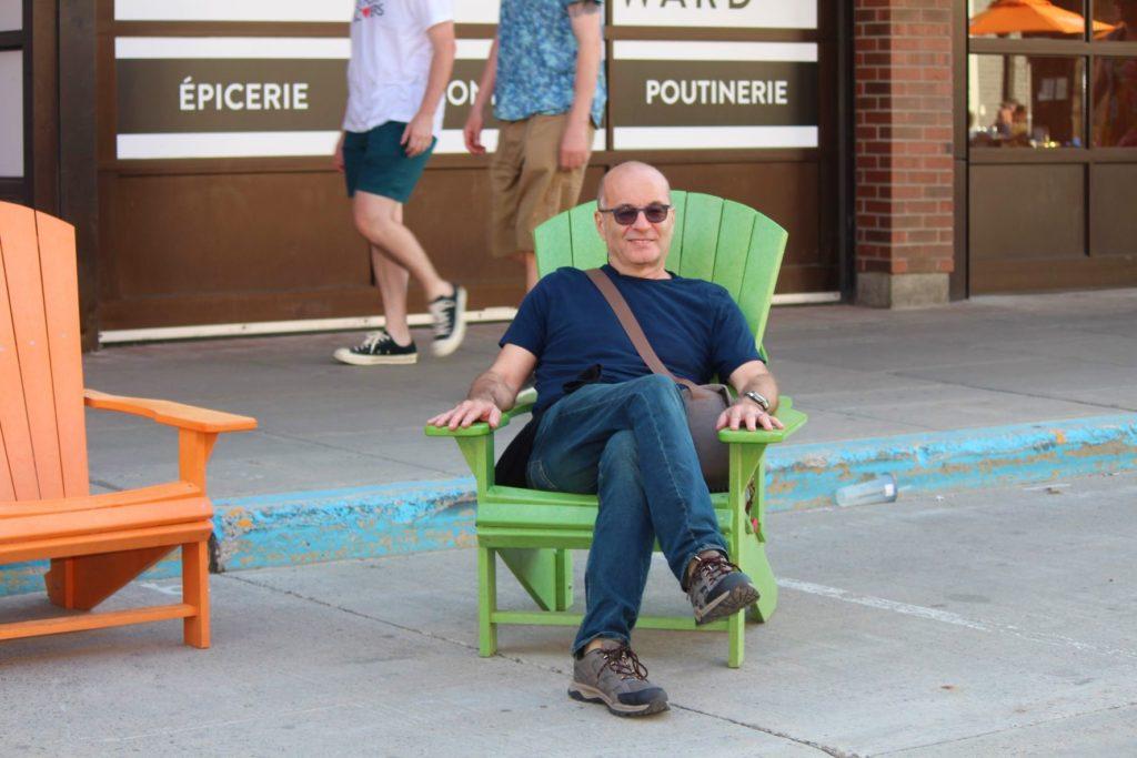 Nick Abbott sitting in a green chair in the city of Ottawa, Canada