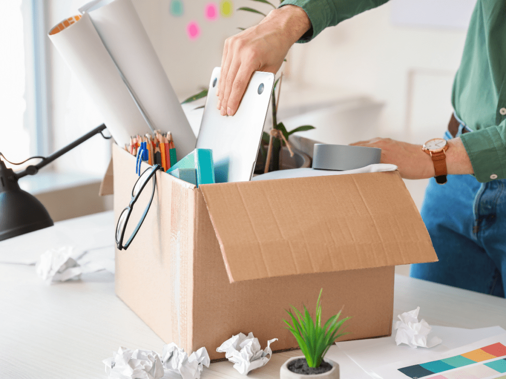 Man packing box with office supplies