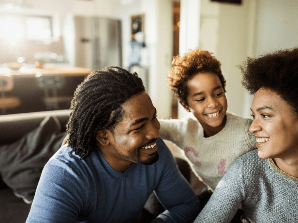 Wife, husband and baby smiling with each other