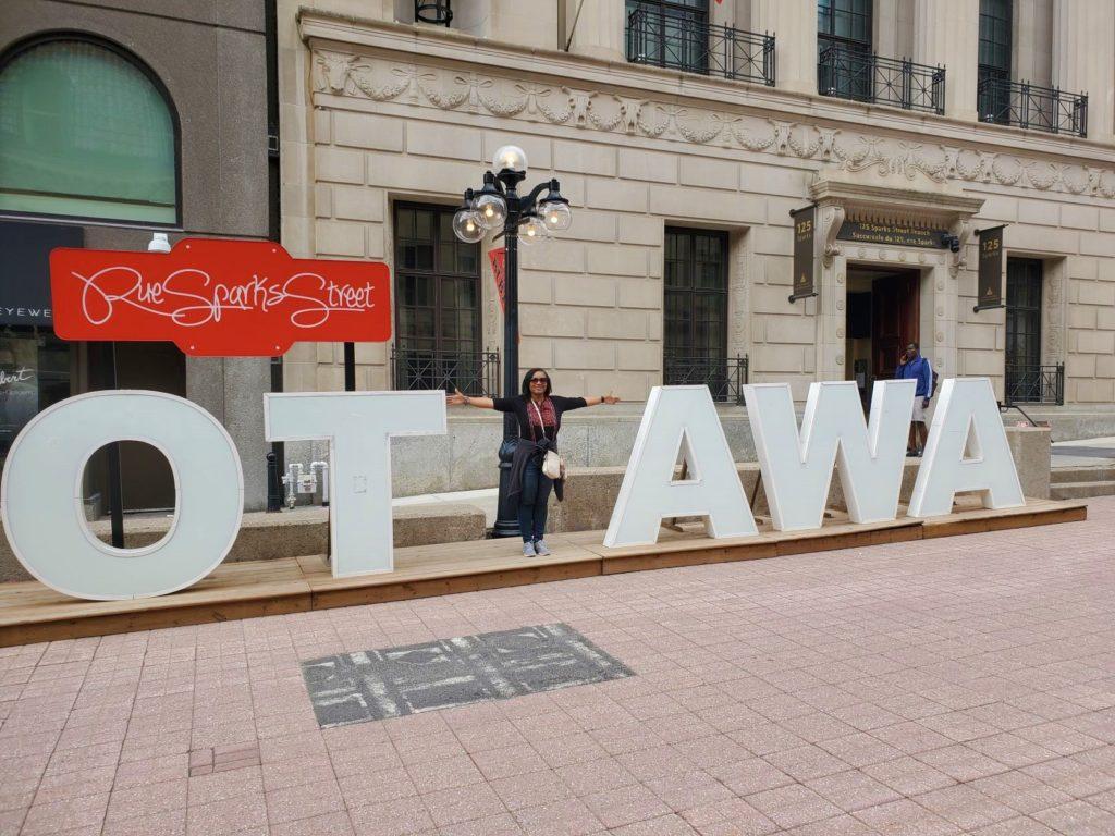 Monique Abbott standing at Ottawa Sign in Downtown Ottawa, Canada