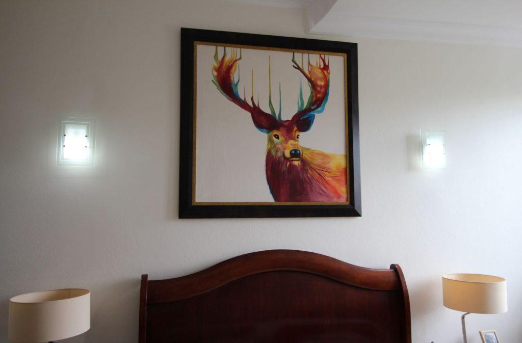 Painting of a stag hanging above bed