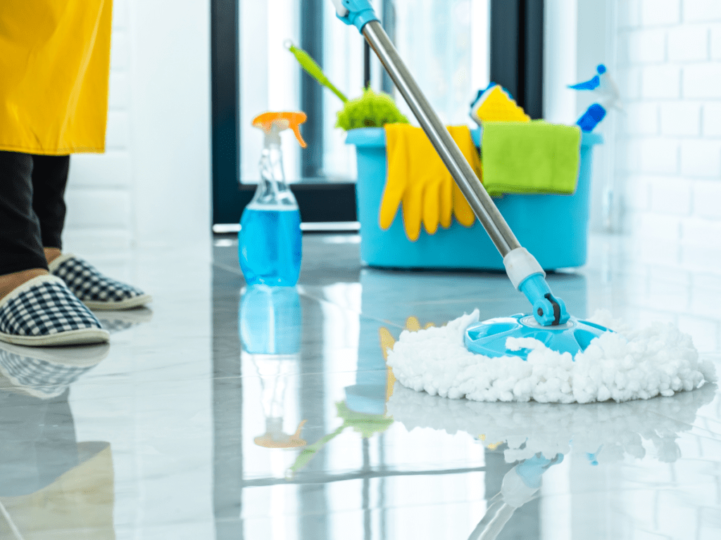 Person wearing apron cleaning floor