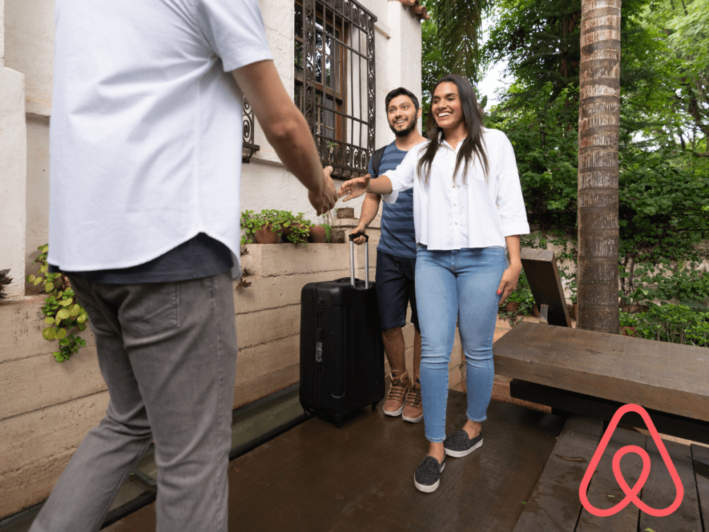 Airbnb Host with outreached arm about to check in Guests