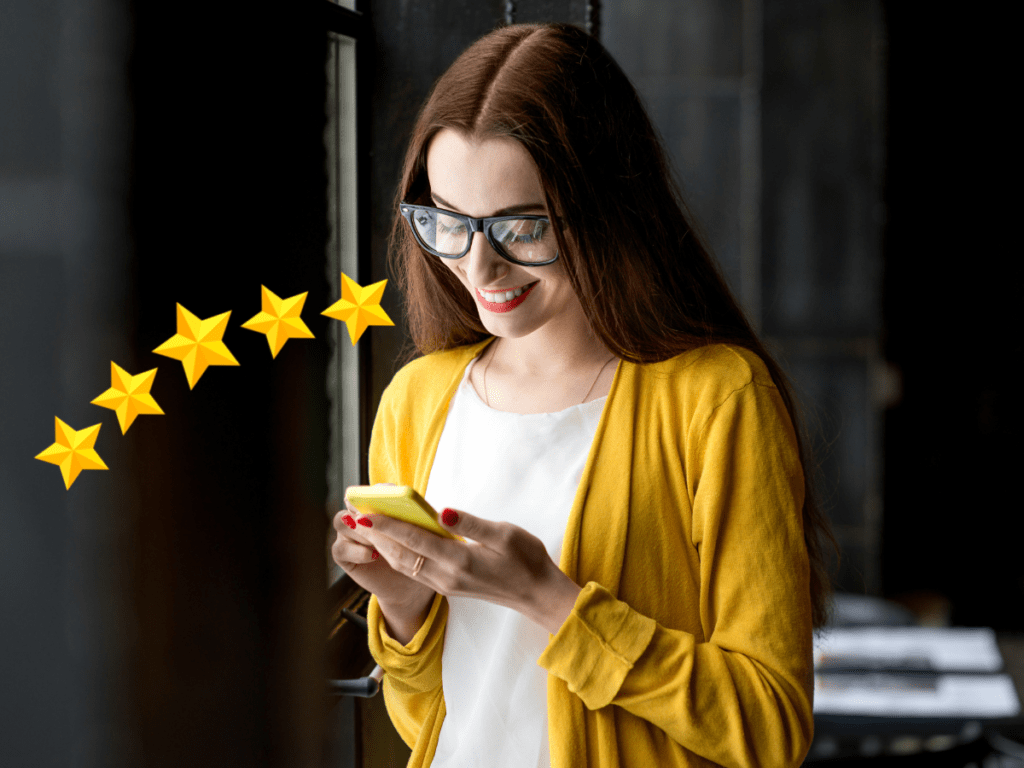 Young Woman Wearing Yellow Sweater wiriting a Five Star Review on her Smartphone