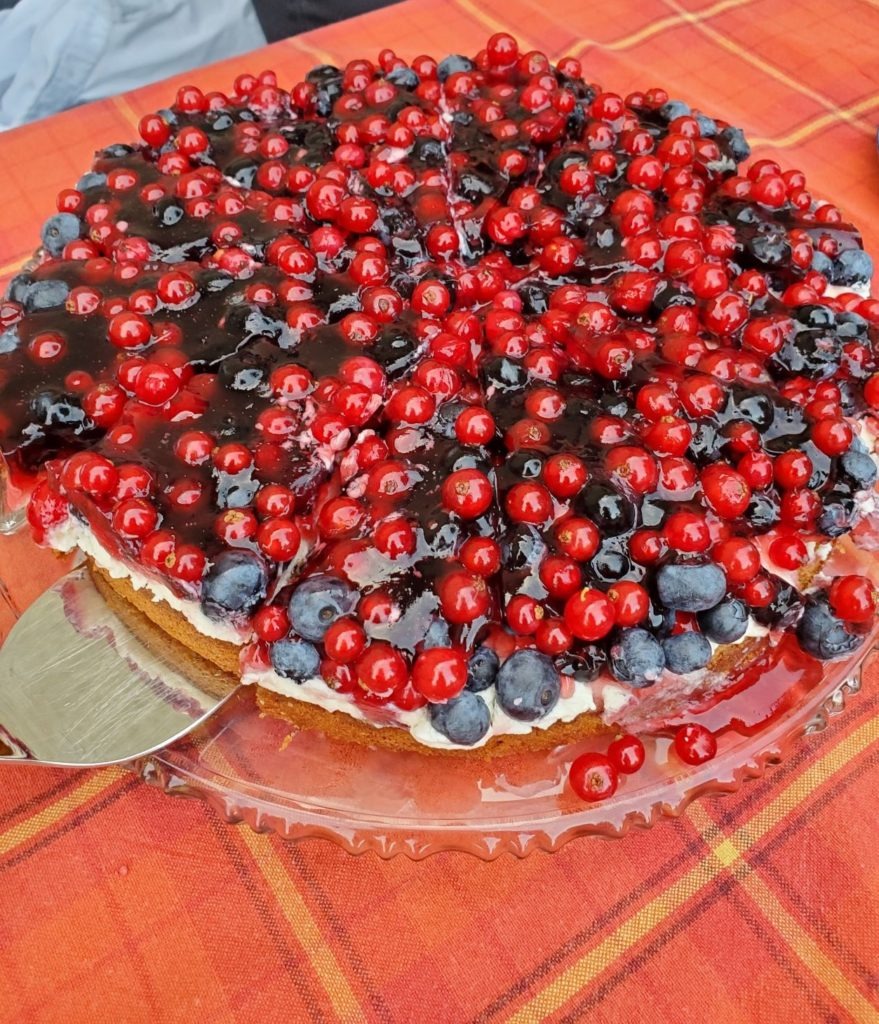 Hazelnut cake topped with blueberries and red currents