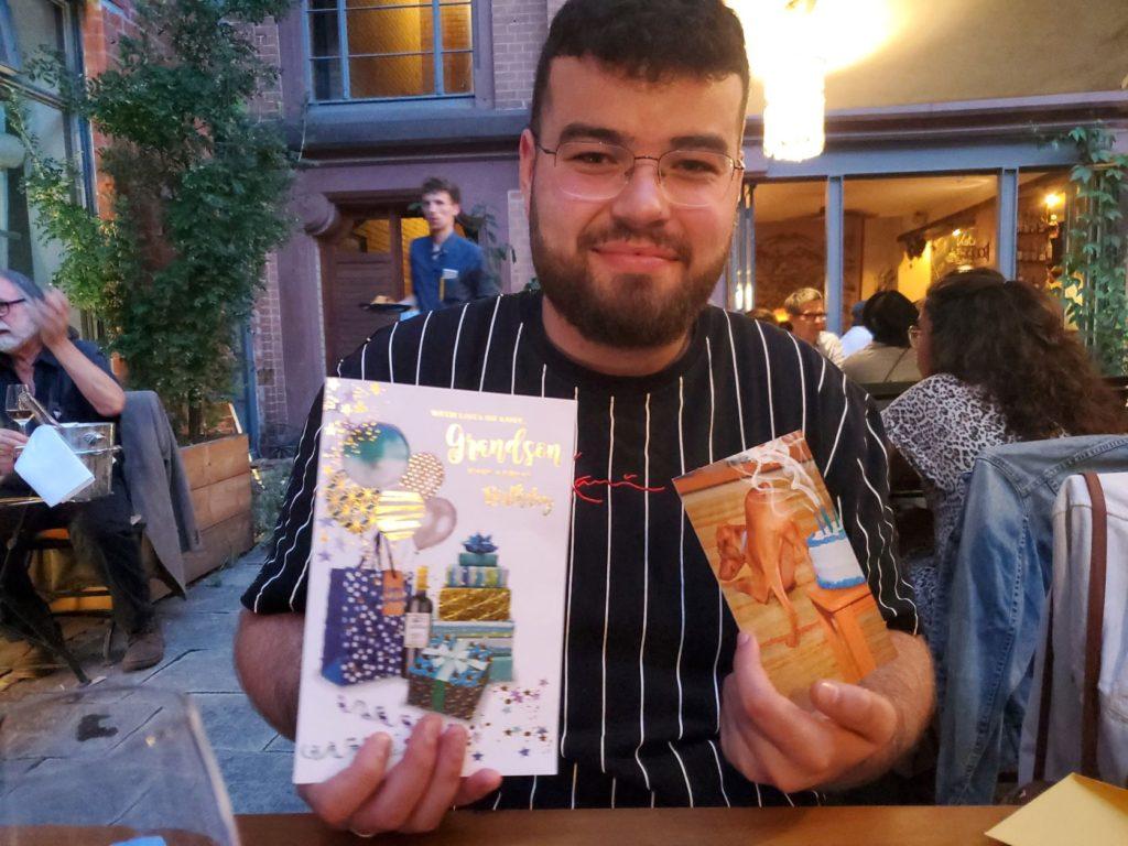 George Abbott showing his birthday cards at the Katz Orange Restaurant, Berlin, Germany
