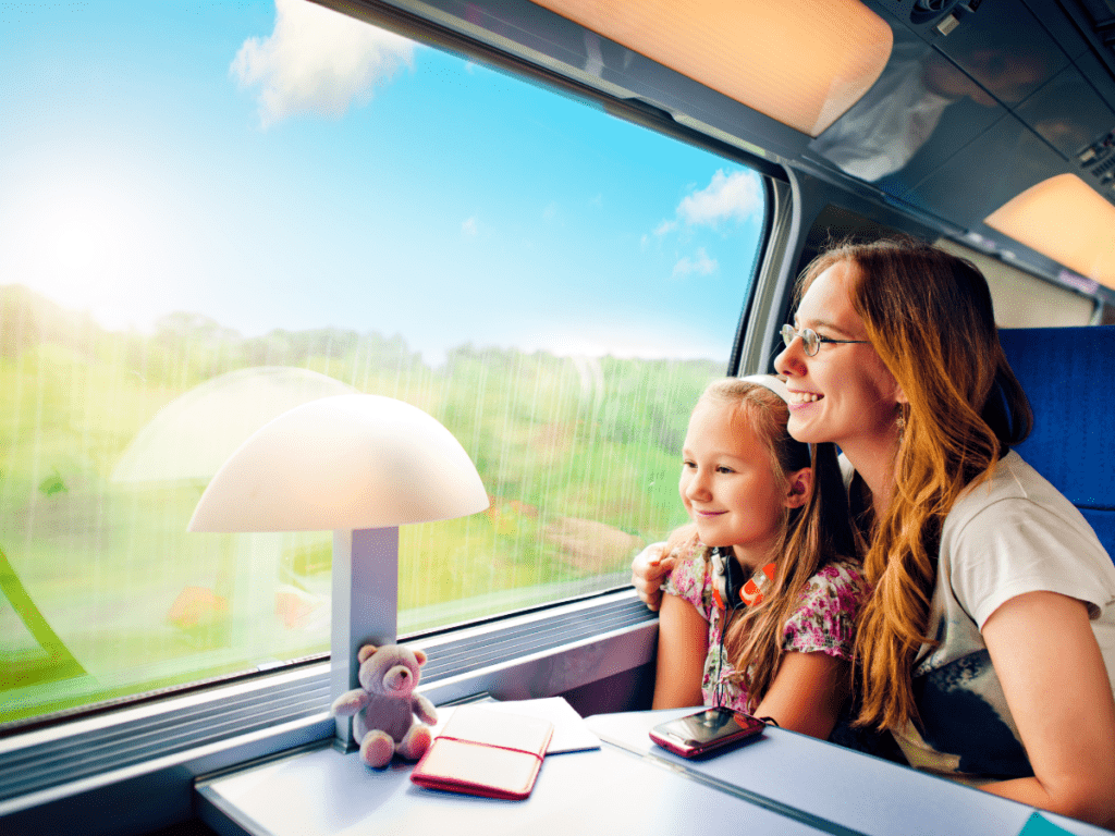 Mother & Daughter Seated Comfortably on Train enjoying the view from window