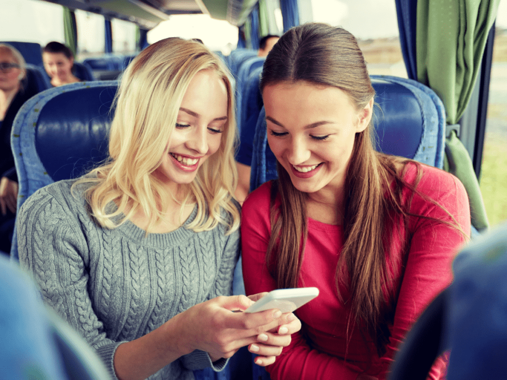 Young Women seated happily on coach bus