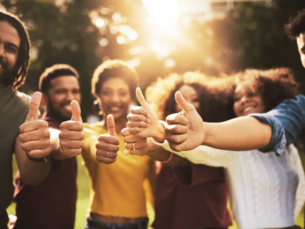 Group of friends all giving a thumbs up