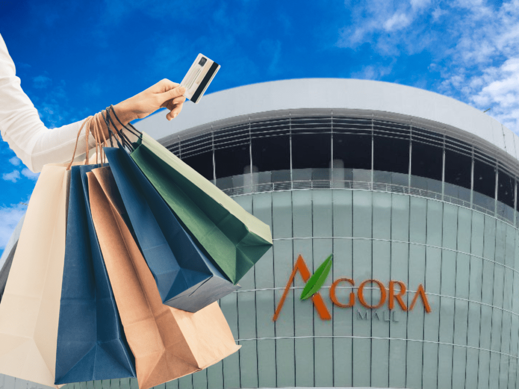 Woman holding up shopping bags and credit card at Agora Mall, Dom Rep