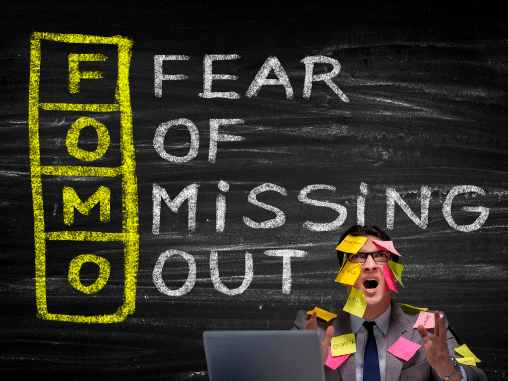 Man looking fearful with fear of missing out sign (fomo) behind him
