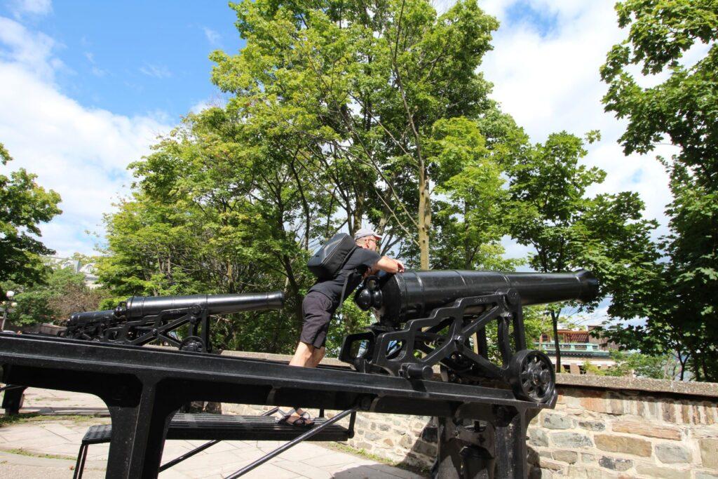 Nick Abbott standing on a canon in Old Town, Quebec City