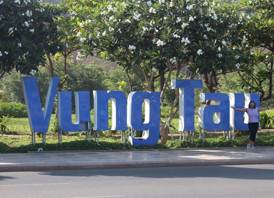 Monique Abbott standing next to Vung Tau sign