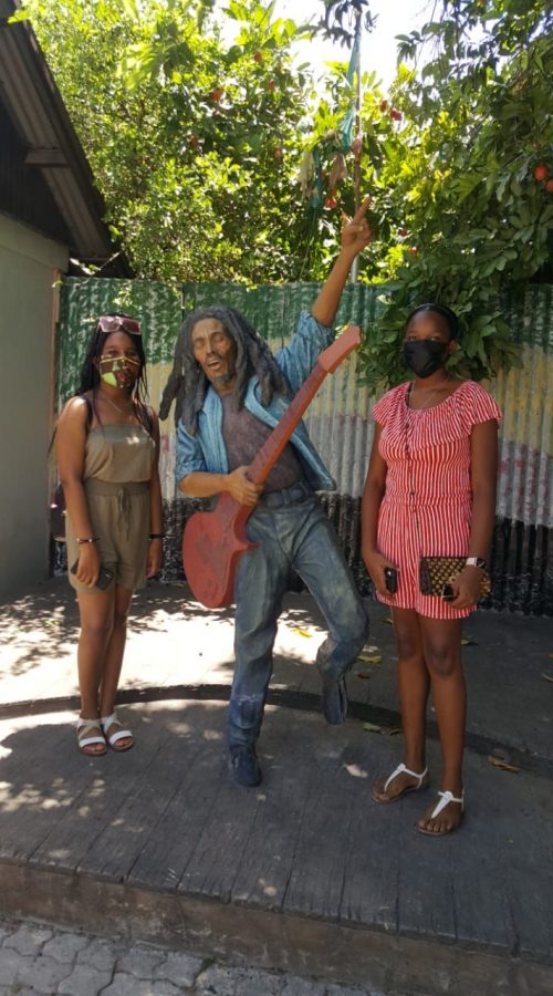 Young ladies standing next to Bob Marley's statue at Trench Town Culture Yard, Kingston, Jamaica